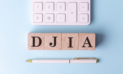 Wall Mural - DJIA on wooden cubes with pen and calculator, financial concept