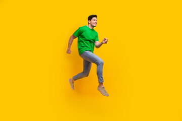 Canvas Print - Full length photo of optimistic pleasant man dressed green t-shirt look at sale empty space running isolated on yellow color background