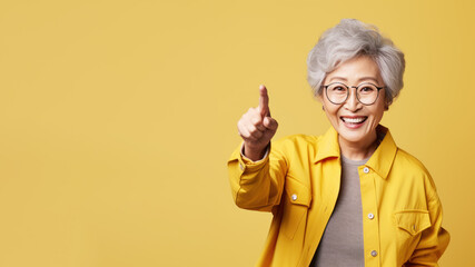 Wall Mural - Happy senior asian woman point her finger at copy space for promotion