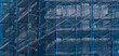 © Yuriy T - building under construction covered in blue mesh tarp protective wrap (safety debris netting during demolition work) scaffolding high rise commercial architecture