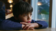 Pensive Child Feeling Boredom At Restaurant, Leaning On Table. Thoughtful Little Boy Daydreaming, Kid Lost In Thought