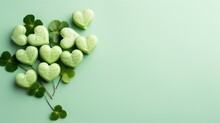  A Bunch Of Green Heart Shaped Candies Sitting On Top Of Each Other On Top Of A Green Surface Next To A Four Leaf Clover.