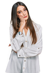 Wall Mural - Young beautiful woman wearing casual white shirt thinking looking tired and bored with depression problems with crossed arms.