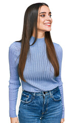Wall Mural - Young beautiful woman wearing casual winter sweater looking away to side with smile on face, natural expression. laughing confident.
