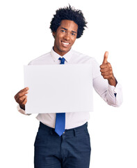 Sticker - Handsome african american man with afro hair holding blank empty banner smiling happy and positive, thumb up doing excellent and approval sign