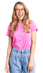 Poster - Young beautiful caucasian woman with blond hair wearing casual clothes and glasses winking looking at the camera with sexy expression, cheerful and happy face.