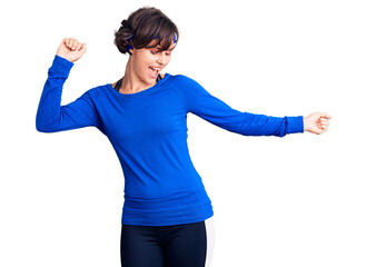 Wall Mural - Beautiful young woman with short hair wearing training workout clothes dancing happy and cheerful, smiling moving casual and confident listening to music