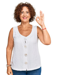 Sticker - Beautiful middle age mature woman wearing casual white shirt smiling positive doing ok sign with hand and fingers. successful expression.