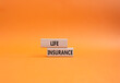 Life insurance symbol. Concept word Life insurance on wooden blocks. Beautiful orange background. Business and Life insurance concept. Copy space