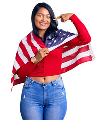 Poster - Hispanic woman with long hair holding united states flag pointing finger to one self smiling happy and proud