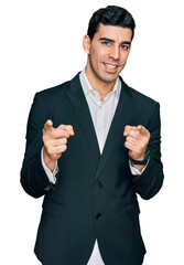 Handsome hispanic man wearing business clothes pointing fingers to camera with happy and funny face. good energy and vibes.