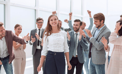 Wall Mural - happy young businesswoman standing in the circle of her colleagues