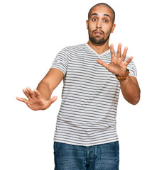 Poster - Hispanic adult man wearing casual clothes afraid and terrified with fear expression stop gesture with hands, shouting in shock. panic concept.