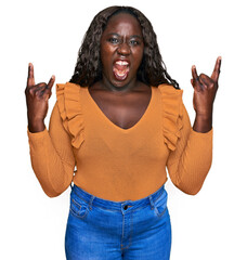 Sticker - Young african woman wearing casual clothes shouting with crazy expression doing rock symbol with hands up. music star. heavy concept.