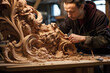 Concentrated male artisan carving elaborate designs into wood.World handicrafts day.