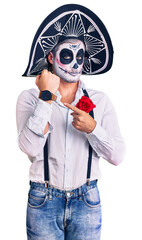 Poster - Man wearing day of the dead costume over background in hurry pointing to watch time, impatience, looking at the camera with relaxed expression