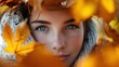 portrait of a feminine models face wrapped in autumn leaves