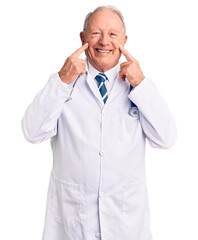 Wall Mural - Senior handsome grey-haired man wearing doctor coat and stethoscope smiling with open mouth, fingers pointing and forcing cheerful smile