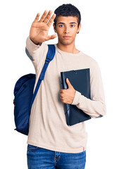 Poster - Young african amercian man wearing student backpack holding binder with open hand doing stop sign with serious and confident expression, defense gesture