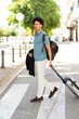 © mimagephotos - traveler crosses a city street with a suitcase
