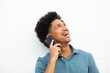 © mimagephotos - happy young man talking with cellphone by white background