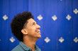 © mimagephotos - side portrait smiling young man with afro