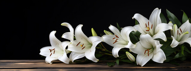 white lily flowers on a wooden table on a dark background