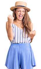 Wall Mural - Young beautiful blonde woman wearing summer hat celebrating surprised and amazed for success with arms raised and eyes closed. winner concept.