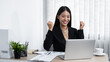 © Ngampol - Young secretary woman smiling and looking on laptop with raising