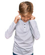 © Krakenimages.com - Little caucasian boy kid wearing casual clothes covering ears with fingers with annoyed expression for the noise of loud music. deaf concept.