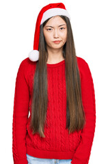 Poster - Young chinese woman wearing christmas hat skeptic and nervous, frowning upset because of problem. negative person.