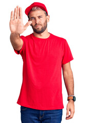 Poster - Young handsome blond man wearing t-shirt and cap doing stop sing with palm of the hand. warning expression with negative and serious gesture on the face.