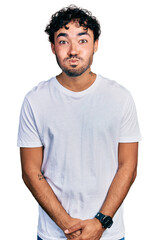 Sticker - Hispanic young man with beard wearing casual white t shirt puffing cheeks with funny face. mouth inflated with air, crazy expression.