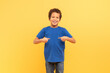 © Prostock-studio - Happy boy pointing at himself with thumbs on yellow background