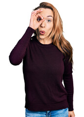 Canvas Print - Young caucasian woman wearing casual clothes doing ok gesture shocked with surprised face, eye looking through fingers. unbelieving expression.