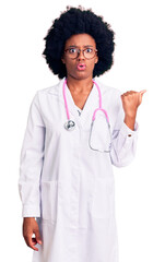 Poster - Young african american woman wearing doctor coat and stethoscope surprised pointing with hand finger to the side, open mouth amazed expression.