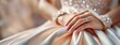 Bridal Hands Clasped in Anticipation. Gently folded arms adorned with a wedding ring, the bride's gown flowing in soft focus. Panorama with copy space.