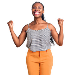 Canvas Print - Young african american woman wearing casual clothes celebrating surprised and amazed for success with arms raised and open eyes. winner concept.