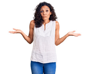 Wall Mural - Middle age beautiful woman wearing casual sleeveless t shirt clueless and confused expression with arms and hands raised. doubt concept.