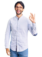 Canvas Print - Handsome hispanic man wearing business shirt and glasses smiling positive doing ok sign with hand and fingers. successful expression.