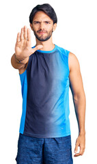 Canvas Print - Handsome hispanic man wearing sportswear doing stop sing with palm of the hand. warning expression with negative and serious gesture on the face.