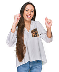 Canvas Print - Young hispanic girl wearing casual clothes celebrating surprised and amazed for success with arms raised and open eyes. winner concept.