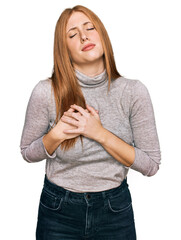 Wall Mural - Young irish woman wearing casual clothes smiling with hands on chest with closed eyes and grateful gesture on face. health concept.