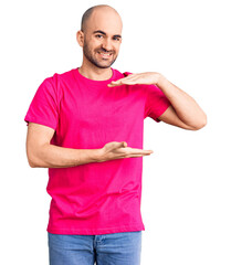 Wall Mural - Young handsome man wearing casual t shirt gesturing with hands showing big and large size sign, measure symbol. smiling looking at the camera. measuring concept.