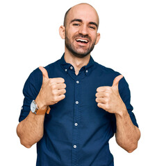 Wall Mural - Young hispanic man wearing casual clothes success sign doing positive gesture with hand, thumbs up smiling and happy. cheerful expression and winner gesture.