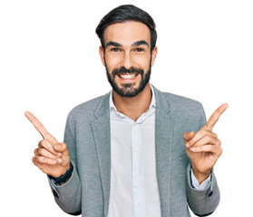 Wall Mural - Young hispanic man wearing business clothes smiling confident pointing with fingers to different directions. copy space for advertisement