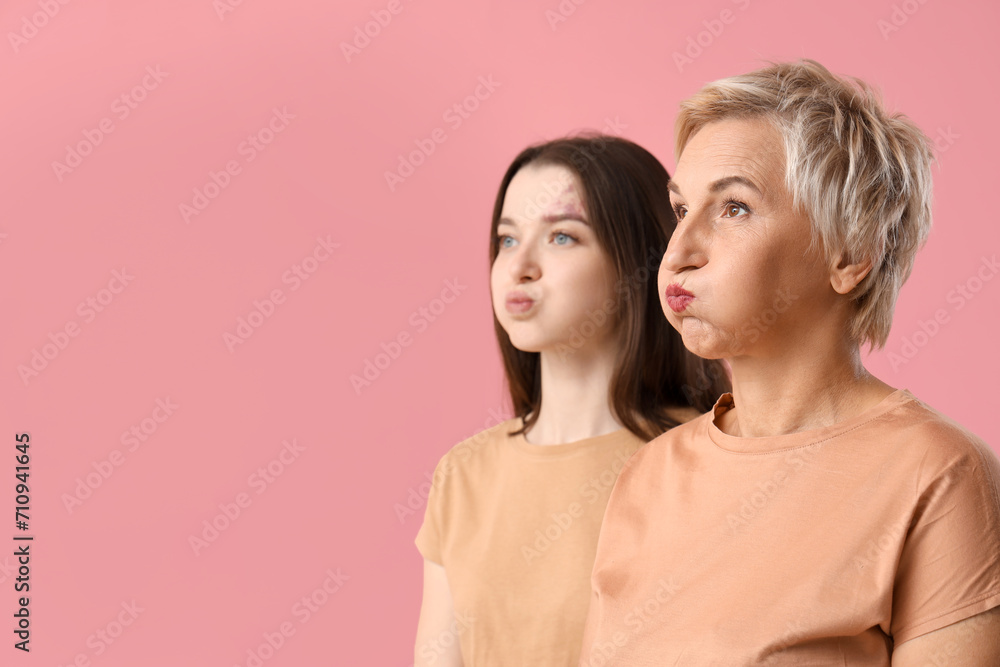 Beautiful women doing face building exercise on pink background