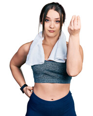 Wall Mural - Young hispanic girl wearing sportswear and towel doing italian gesture with hand and fingers confident expression