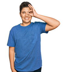 Poster - Teenager hispanic boy wearing casual clothes doing ok gesture with hand smiling, eye looking through fingers with happy face.