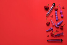 Composition With Beautiful Rose Flowers And Different Sex Toys On Red Background